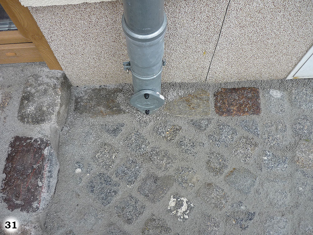 Ein im Boden eingelassendes Wasserrohr mit Zugang an einer Hauswand