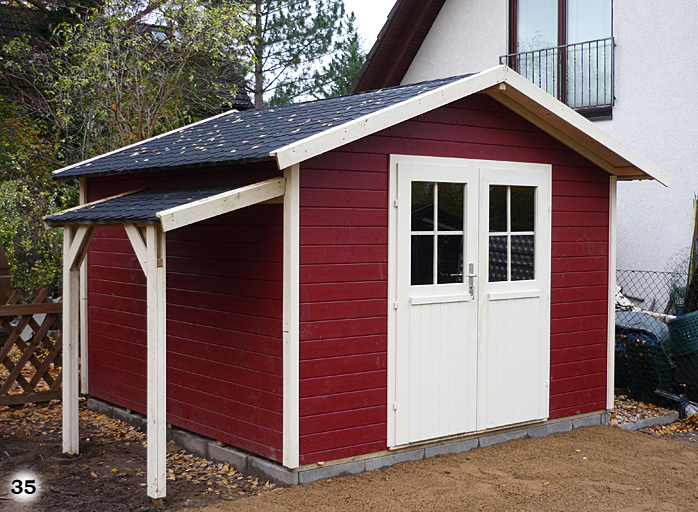 Stilvolles rotes Holzhaus in einem Garten