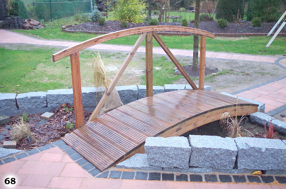 Eine abgerundete Holzbrücke an dem links ein Geländer angebracht wurden ist