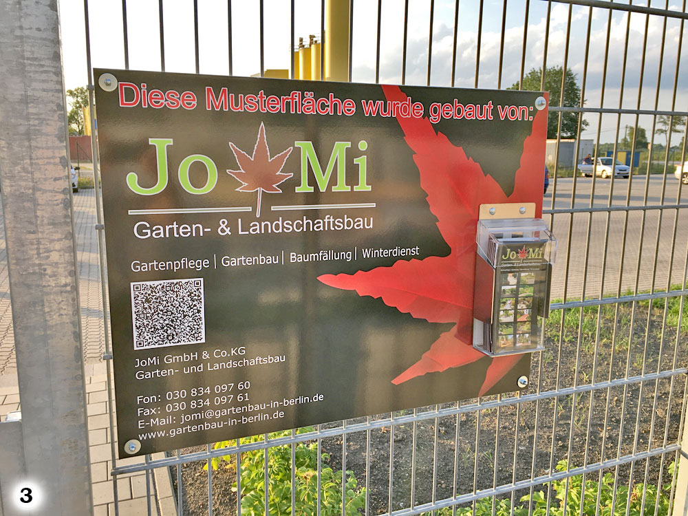 Firmenschild von JoMi Garten- & Landschaftsbau mit einer Flyerbox