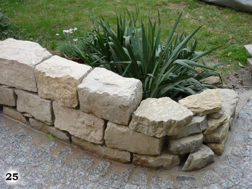 Kleine altmodische Mauer um einer Pflanze an einem Gehweg