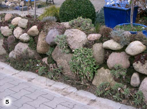 Abenteuerliche Mauer zusammengesetzt aus vielen verschiedenen förmlichen Steinen