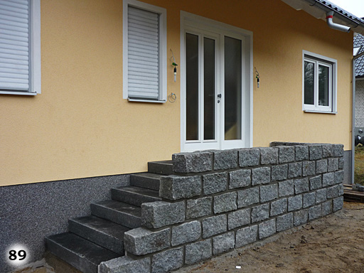 Eine Treppe zu einem Hauseingang mit einer kleinen dazu passenden Mauer