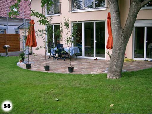 Vorhof aus kleinen, dunkel grauen, quadratischen Pflastersteinen mit Gullydeckel