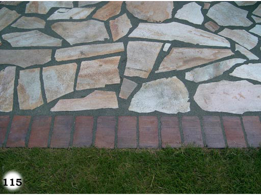 nicht symmetrische, helle Steinplatten von Rasenfläche getrennt durch rote Pflastersteine