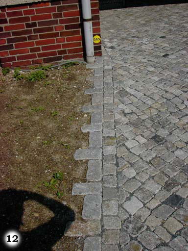  Weg aus kleinen, grauen, quadratischen Pflastersteinen verläuft in Rasenfläche