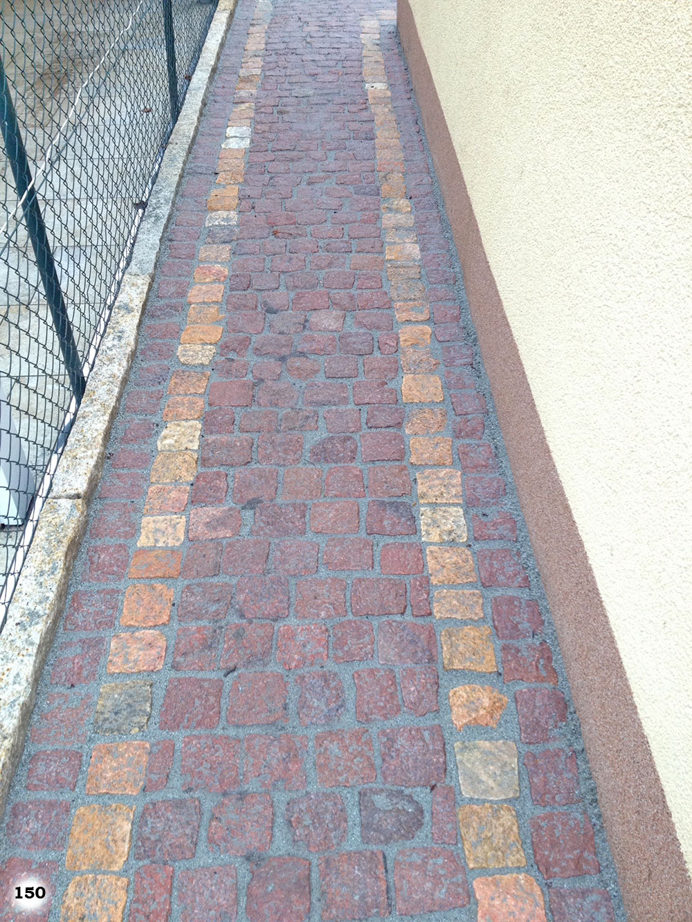 roter Pflastersteinweg mit zwei Streifen aus gelben Pflastersteinen