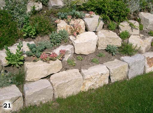 Stufenbeet aus hellen, großen Quadratischen Steinen, liebevoll als Stufen angelegt und mit verschiedenen Pflanzen bepflanzt