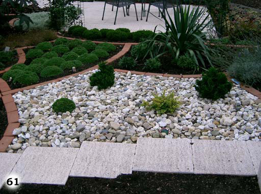 Eine abgegrenzte Fläche in einem Garten mit Kieselsteinen bedeckt