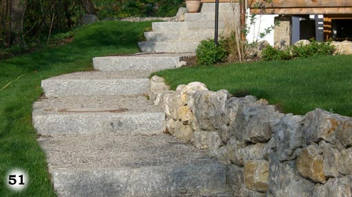 Eine graue Treppe mit langen Stufen welche in einer Schräge nach oben führt