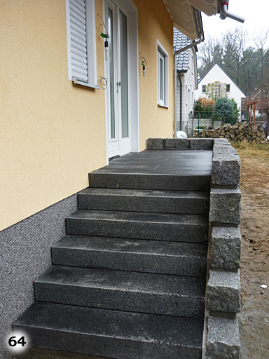 Dunkle Holztreppe mit grauen Steinpfählen an der Seite