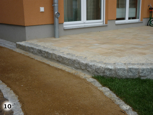 Eine Stufe von einem Gehweg zu einer Terrasse