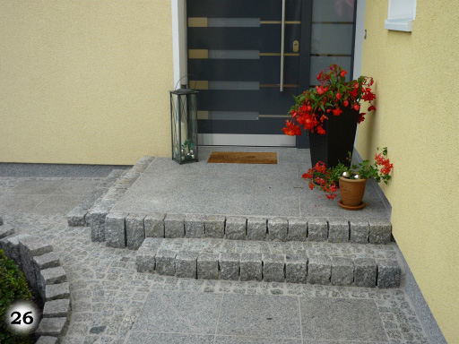 Stufen zu einem Hauseingang auf dem sich hübsche Topfpflanzen befinden
