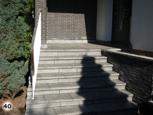 Graue Treppen mit einem schönen weiß schwarzen Geländer