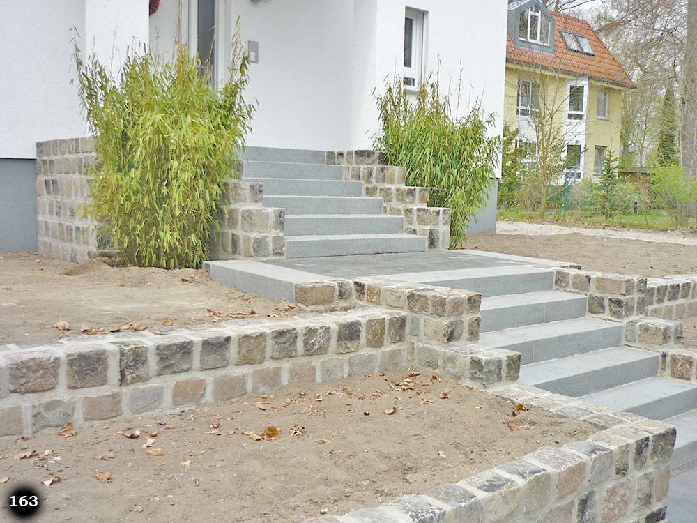Eine moderne graue Treppe in einer hohen Steigung an einem Haus