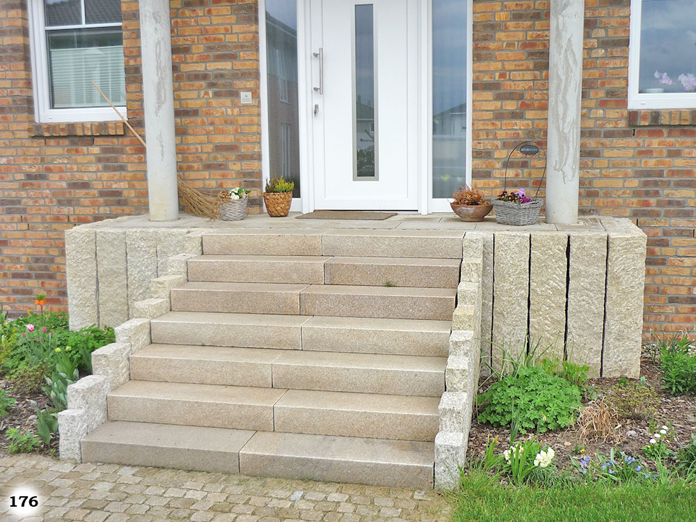 Eine lange Treppe mit schmalen Stufen an einer Haustür vor der sich Topfpflanzen befinden
