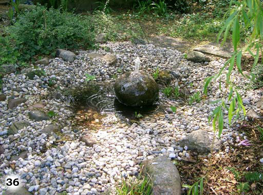 Ein Stein in der Form einer Kugel aus dem Wasser heraus spritzt